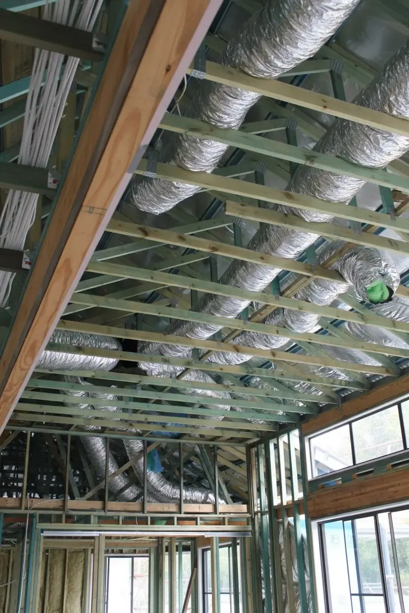 Ducting being installed through an open roof frame