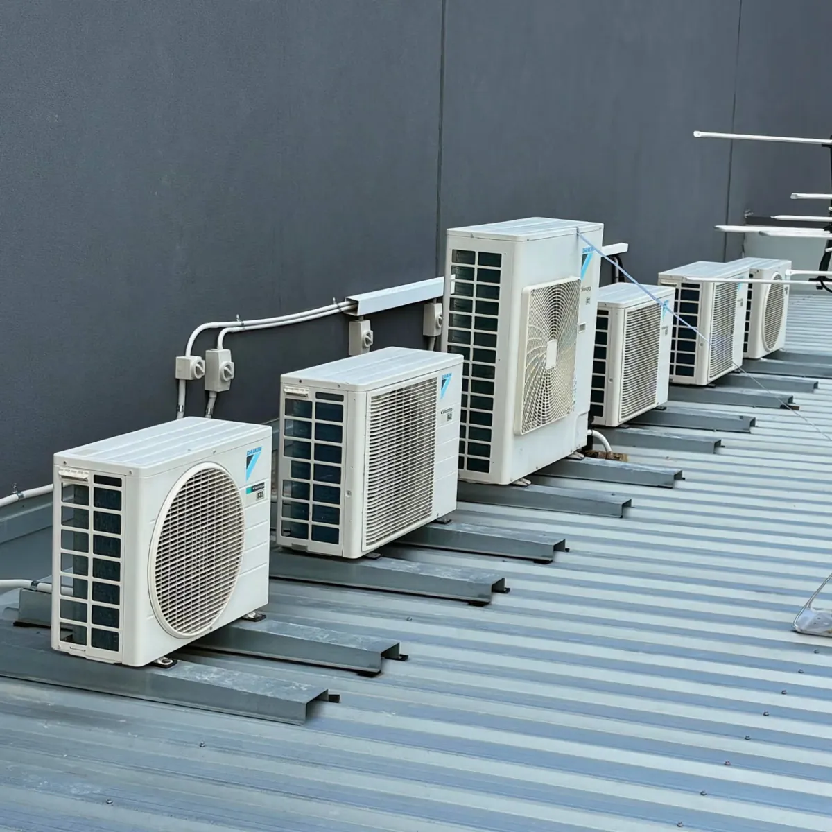 Row of split system outdoor units installed on a commercial roof in Perth